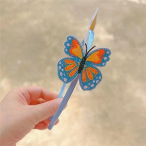 Close-up of glittery blue butterfly headband with colorful wings for children