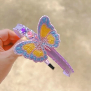 Detail of purple fabric headband with embroidered butterfly and heart-shaped rhinestones