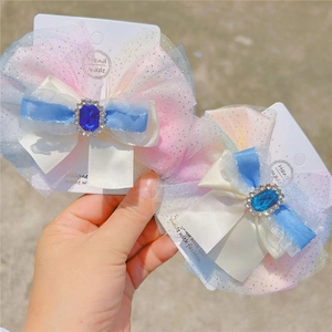 Détail de la pince à nœud en tulle avec pierre bleue et strass brillants