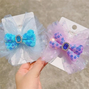 Detailed view of sequin mesh bow hair clips with blue crystals on display card