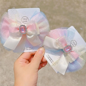 Détail de pinces à cheveux nśud en mesh dégradé avec strass roses sur carte support