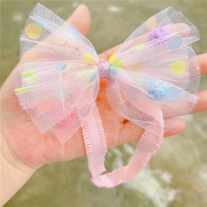 Detailansicht eines rosa Tüll-Stirnbandes mit bunten Punkten für Babymädchen
