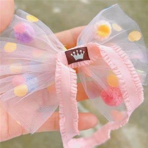 Detaillierte Nahaufnahme: Rosa Tüll-Stirnband mit bunten Punkten und Kronen-Logo für Babys