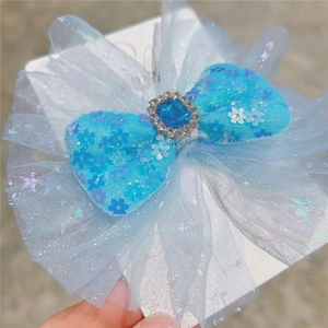 Close-up of blue mesh hair bow with sequin flowers and a central square gemstone