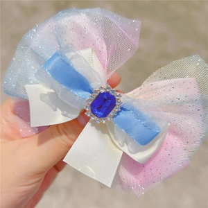 Gros plan détaillé du nœud à cheveux en tulle dégradé avec une pierre précieuse bleue