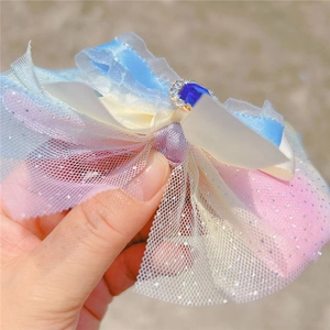 Détail d'une pince à cheveux nœud en tulle dégradé avec saphir synthétique et paillettes