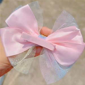 Détail de la pince à cheveux nœud rose avec clip crocodile en métal recouvert de tissu
