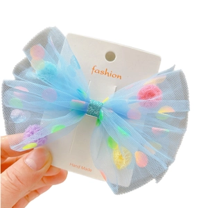 Blauer Tüll-Haarclip für Mädchen mit bunten Pompons auf einer weißen Displaykarte