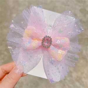Pink and purple mesh bow hair clip with sequins, stars, and center gemstone