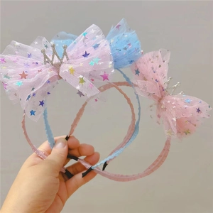 Détail de serre-tête pour fille avec nœud en tulle étoilé et couronne scintillante
