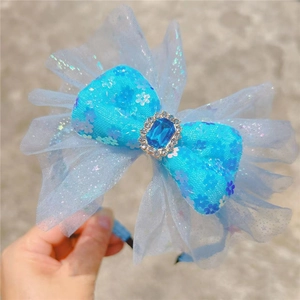 Close-up of blue princess headband with sequins mesh bow and large crystal gem