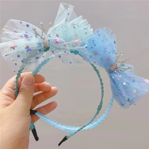 Détail de serre-têtes bleus avec nœuds en résille, étoiles colorées et petites couronnes