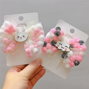 Detail of mesh bow hair clips with colorful pom-poms and cute rabbit decorations