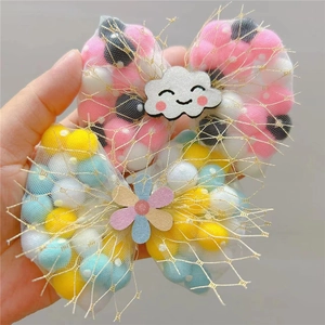 Detail of cute hair clips with colorful pom poms and mesh bows for little girls