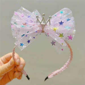 Détail d'un serre-tête nœud en tulle rose avec sequins étoiles et couronne argent