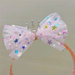 Détail d'un serre-tête rose avec nœud en tulle, étoiles à paillettes et couronne argentée