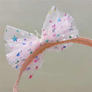 Détail du serre-tête nœud en résille rose avec étoiles pailletées et perle centrale