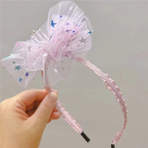 Détail d'un serre-tête rose pour enfant avec grand nœud en tulle et étoiles pailletées