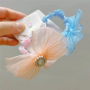 Detail of blue and peach mesh bow hair ties with pearl sunflower charms and elastic bands