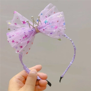 Détail du nœud en tulle violet avec étoiles et couronne de strass sur le serre-tête