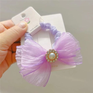Detail of lilac mesh bow hair tie with faux pearl and rhinestone floral trim on card
