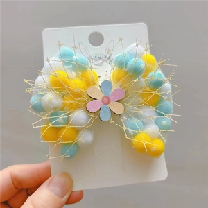Cute white mesh bow hair clip with colorful pom poms and floral detail for girls