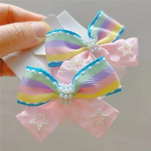 Detail of colorful rainbow striped hair clips with pearl beads and pink ribbon