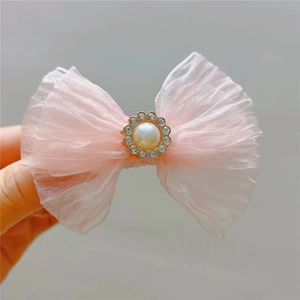 Detail of pink mesh bow hair clip with faux pearl and sparkling rhinestone center