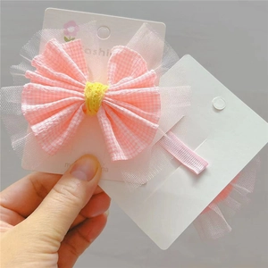 Détail du lot de barrettes à nœud rose à carreaux avec dentelle sur carte