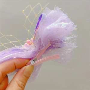Detail einer lila Tüll-Haarspange mit silbernen Pailletten und rosa Metallverschluss