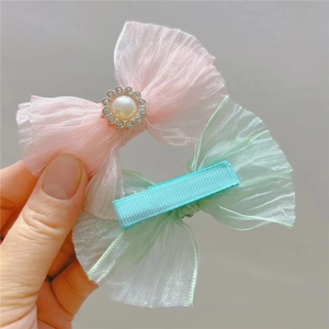 Detail of pink and mint green mesh bow hair clips with pearls and rhinestones