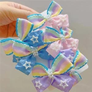 Detailed shot of bow hair clips with pearls and colorful stripes for girls