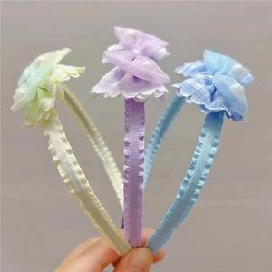 Dettaglio di tre cerchietti colorati con fiocchi in tessuto verde, viola e blu per bambina