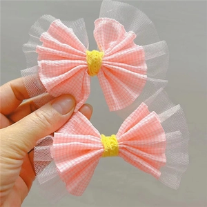 Gros plan de barrettes à carreaux roses avec centre jaune et dentelle blanche