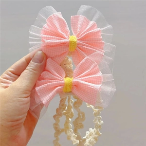 Détail du bandeau avec nœud à carreaux rose et dentelle blanche pour bébés filles