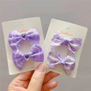 Détail de nœuds en dentelle violette et pinces florales avec gemmes en cœur