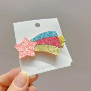 Glittering star and rainbow tail hair clips for kids on a white display card