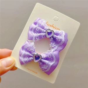 Détail d'un nœud papillon en satin violet avec dentelle et gemme cœur sur carte