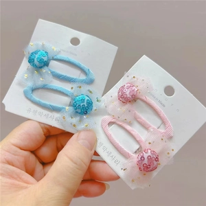 Détail de barrettes à nœuds pailletés pour filles présentées sur carte de support