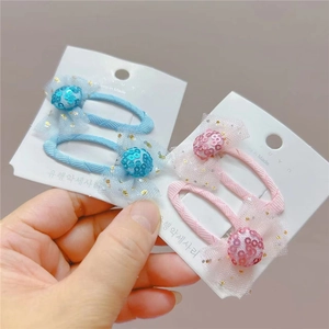 Vue détaillée de barrettes à nœuds pailletés bleu et rose pour filles sur carte
