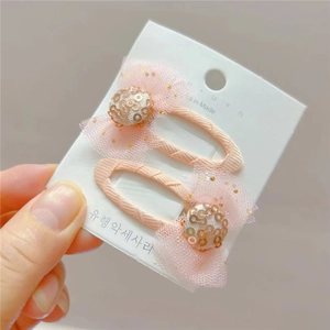 Détail d'une barrette à cheveux rose avec nœud et paillettes pour petites filles