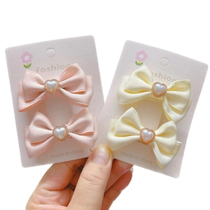 Zwei Haarklammern mit Schleifen und Herzperlen in Pink und Beige für kleine Mädchen