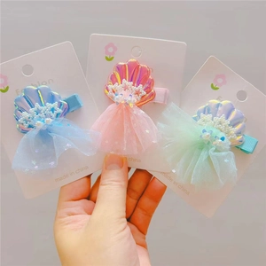 Detailed view of sea shell hair clips with pearls, stars and mesh for kids