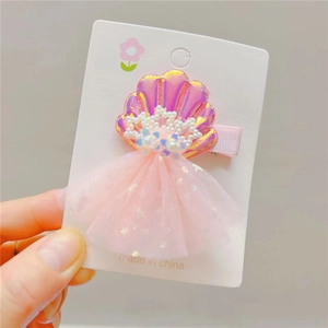 Detail of pink laser shell hair clip with pearls and sparkling mesh tulle for kids