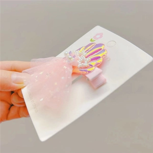 Detail of pink shell hair clip with iridescent finish, pearls and mesh star bow