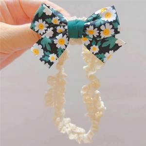Bandeau bébé avec nœud fleuri vert foncé et dentelle élastique beige pour nouveau-né