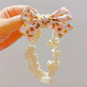 Bandeau bébé avec nœud floral rose, motif marguerite et dentelle élastique douce