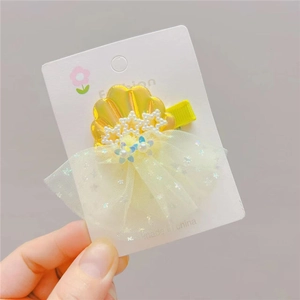 Detail of yellow shell hair clip with pearls and glittery mesh star for girls