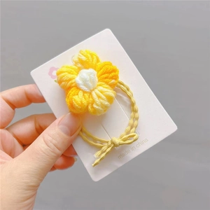 Detailaufnahme von handgemachtem Häkel-Sonnenblumen-Haargummi mit gelben Blütenblättern