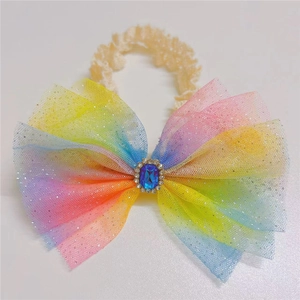 Detail of baby headband featuring rainbow gradient tulle bow and sparkling blue gemstone center